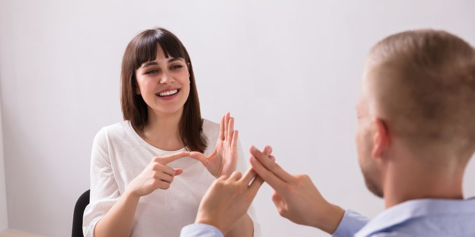 eine Frau und ein Mann unterhalten sich in Gebärdensprache