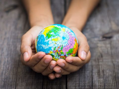 Zwei Hände, die einen Globus halten.